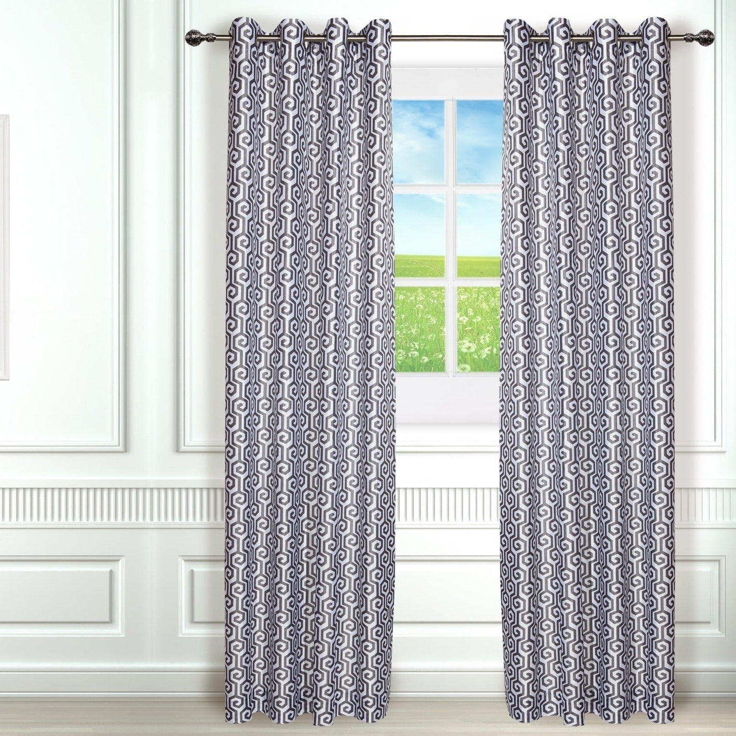 Patterned curtains on a window with a plant and framed picture in the room.