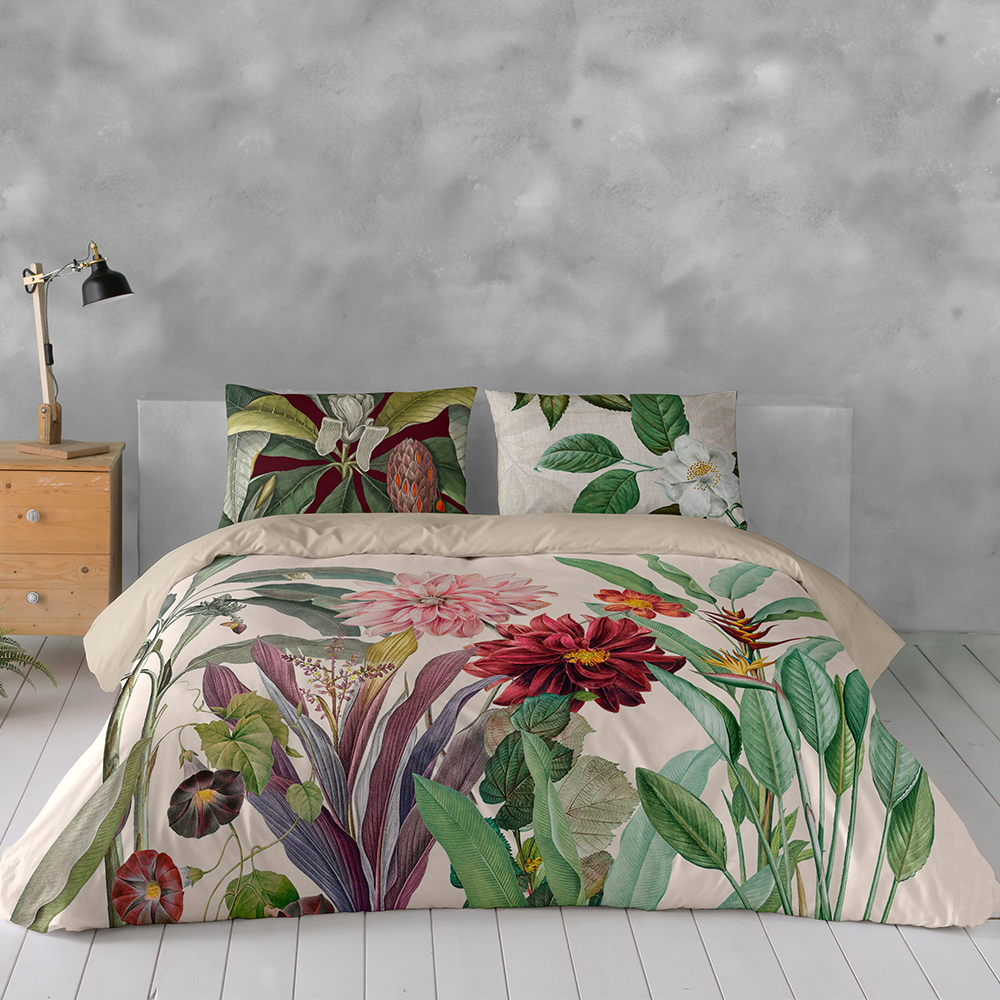 Floral bedding set on a bed with a gray wall and wooden nightstand in the background.