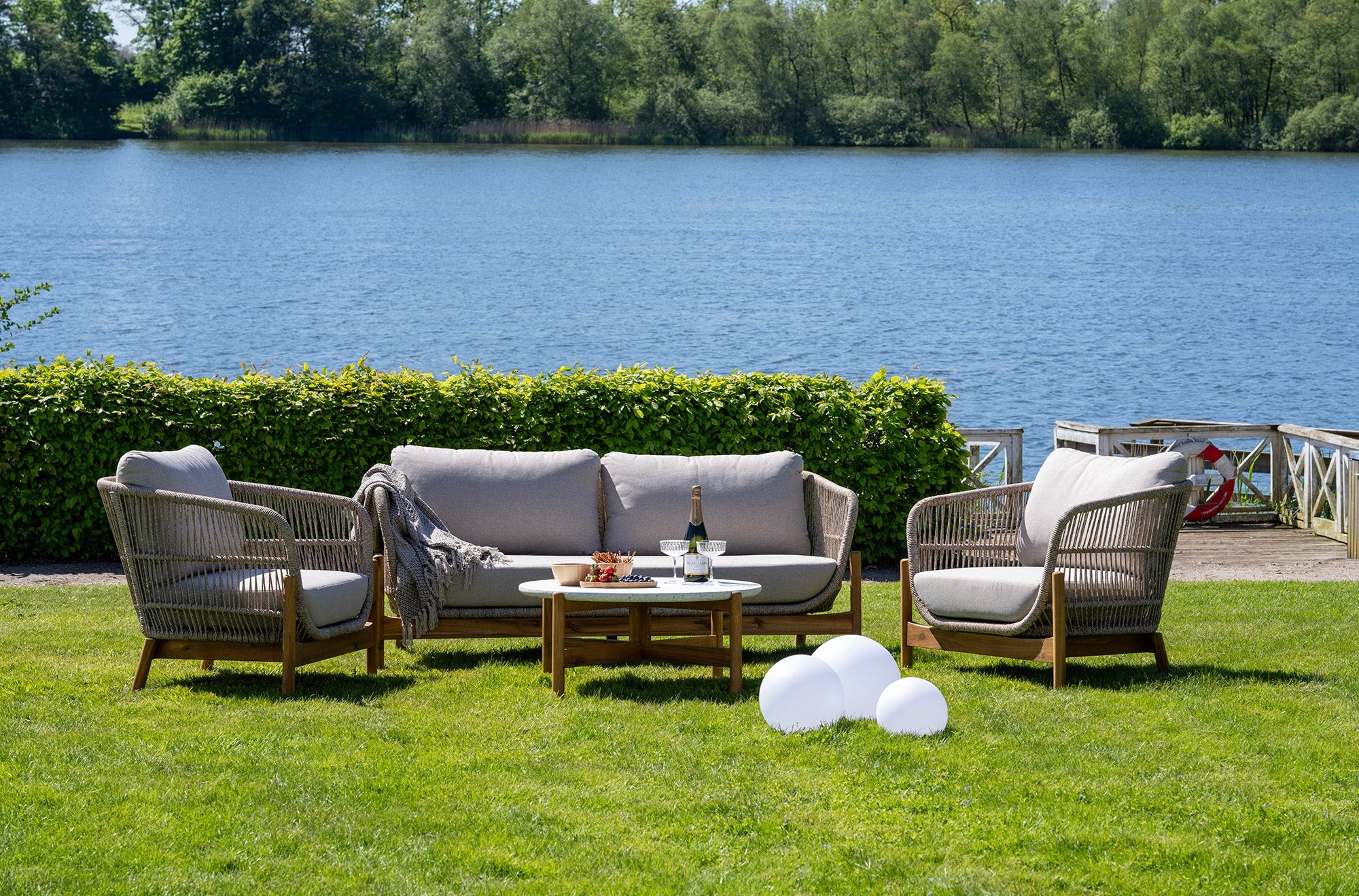 Outdoor patio set with chairs and a table by a lake