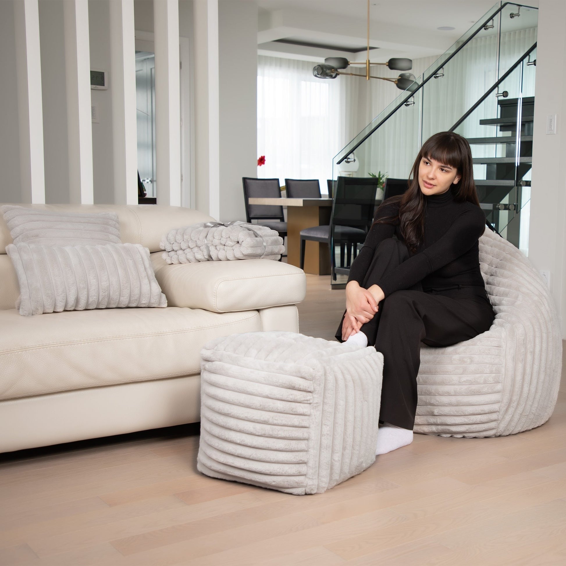 Woman sitting on a textured chair in a modern living room.