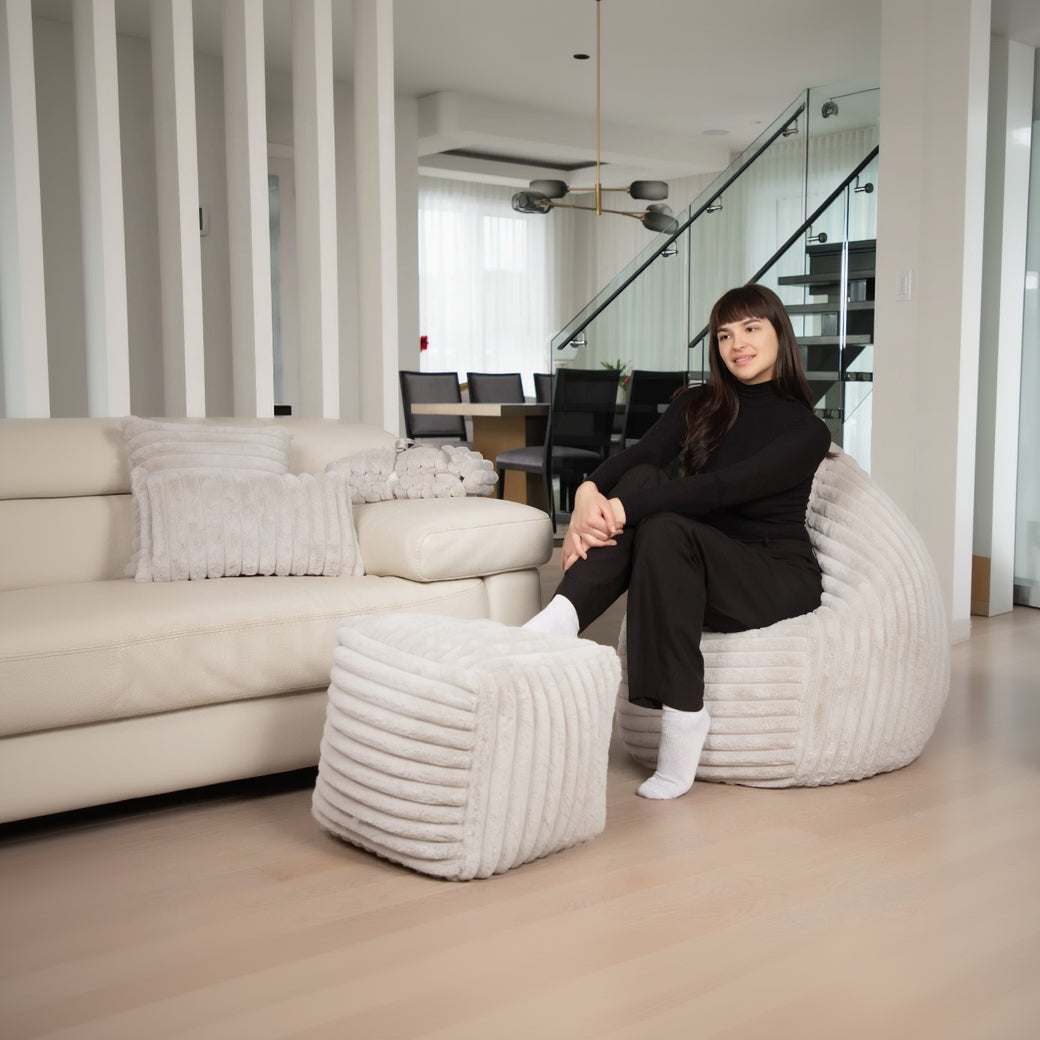 Woman sitting on a textured chair in a modern living room.