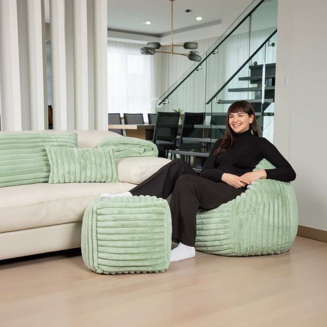 Woman sitting on a green textured chair in a modern living room.