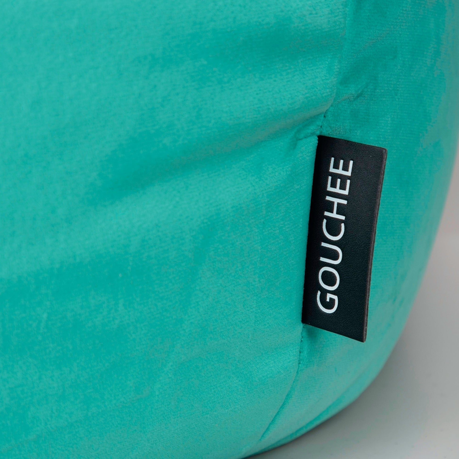 Teal bean bag with 'Gouchee' label on a white background