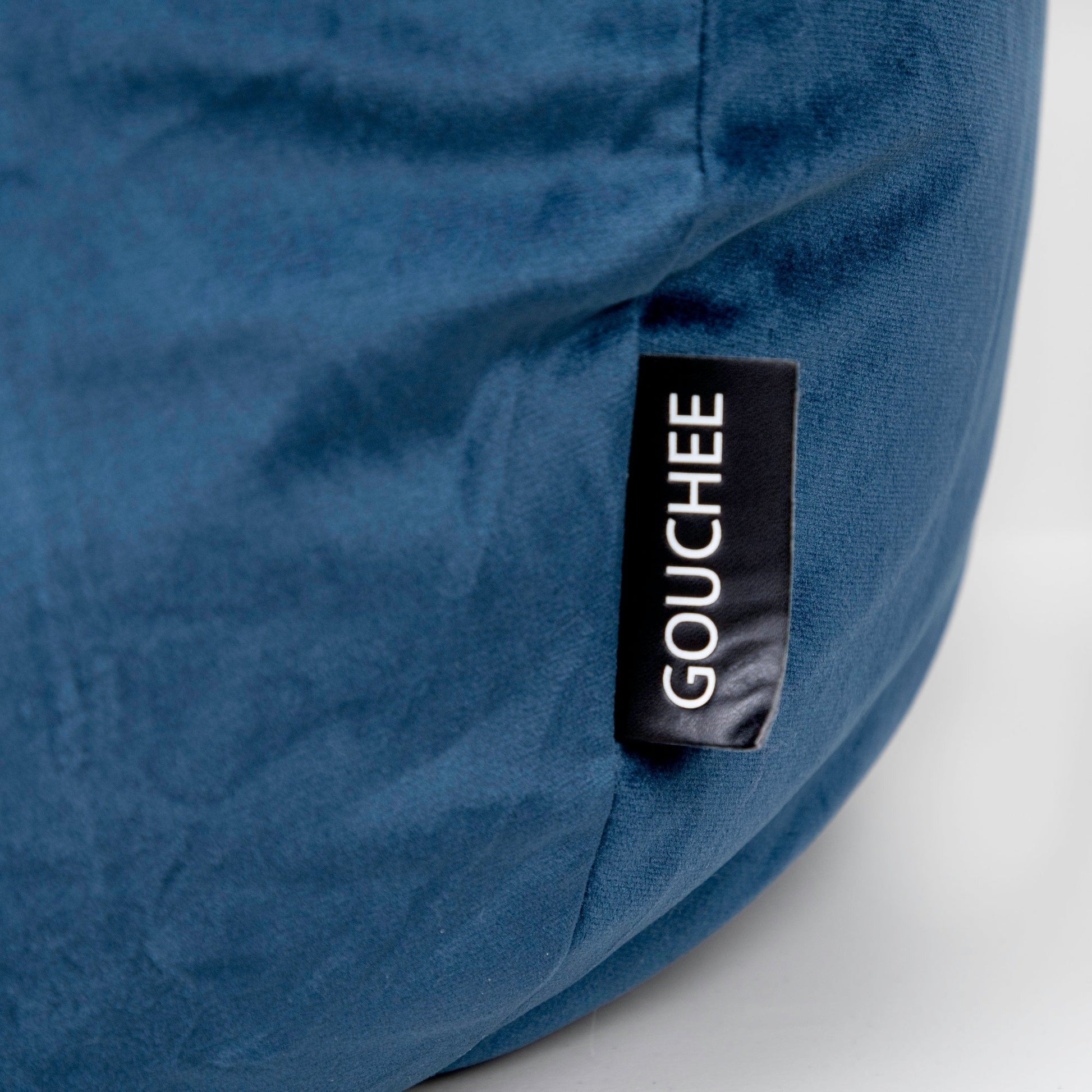 Blue bean bag with 'Gouché' label on a white background