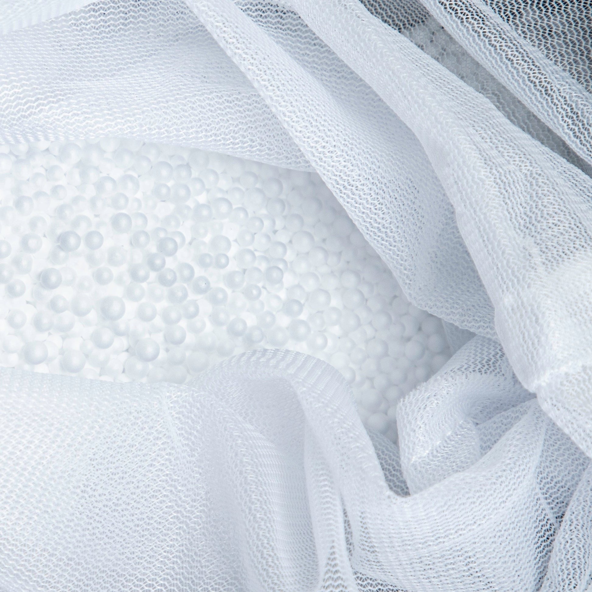 Close-up of white textured fabric with a mesh overlay