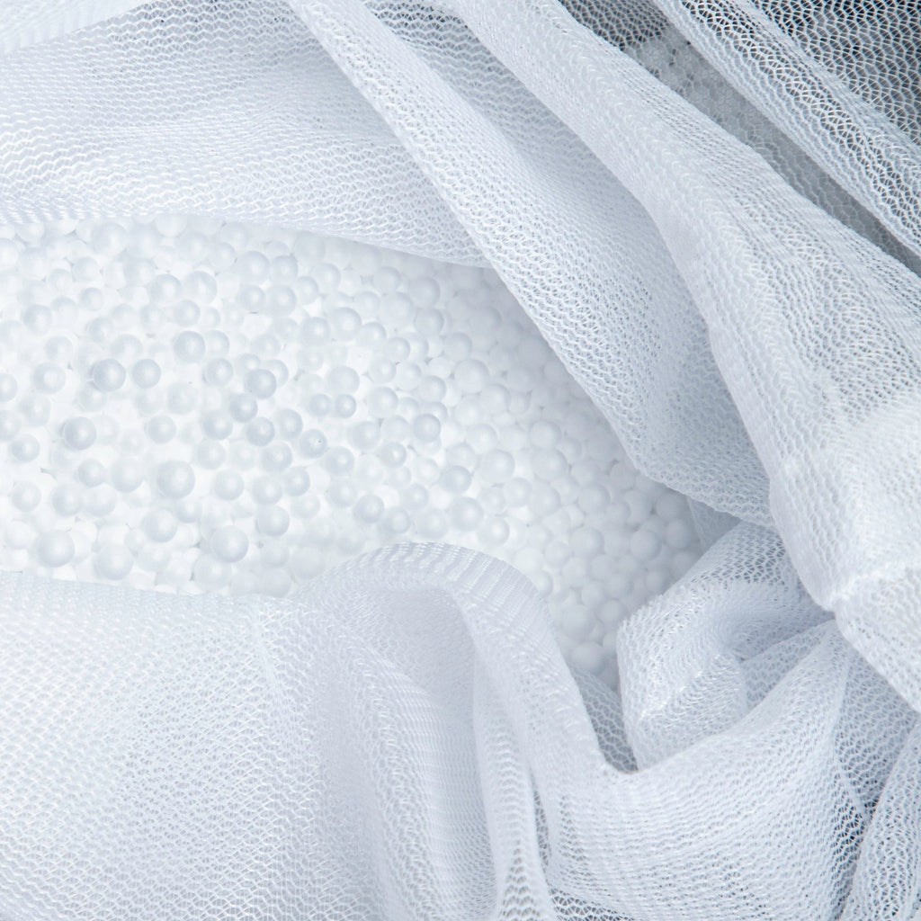 Close-up of white textured fabric with a mesh overlay