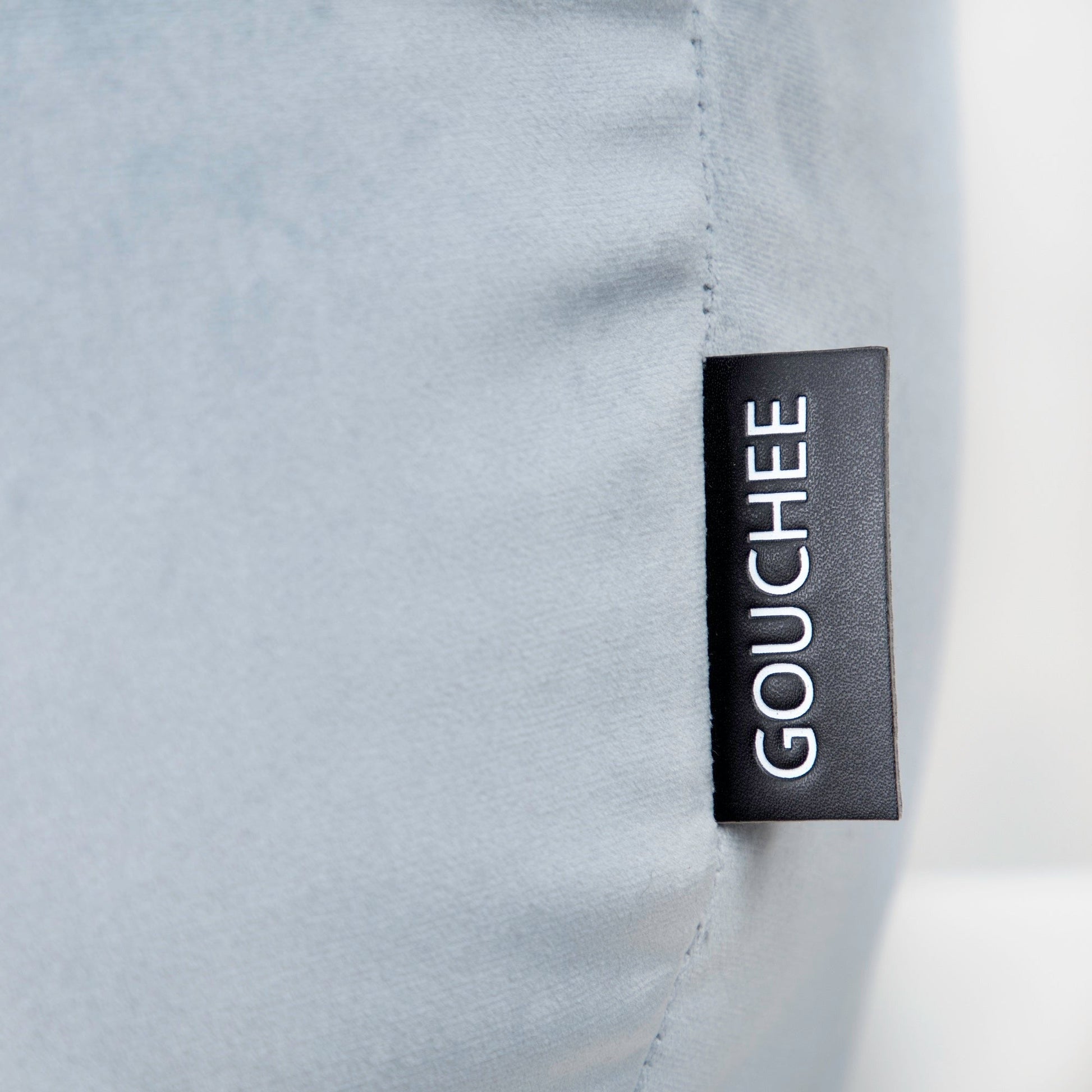 Close-up of a gray fabric with a 'Gouchee' label.