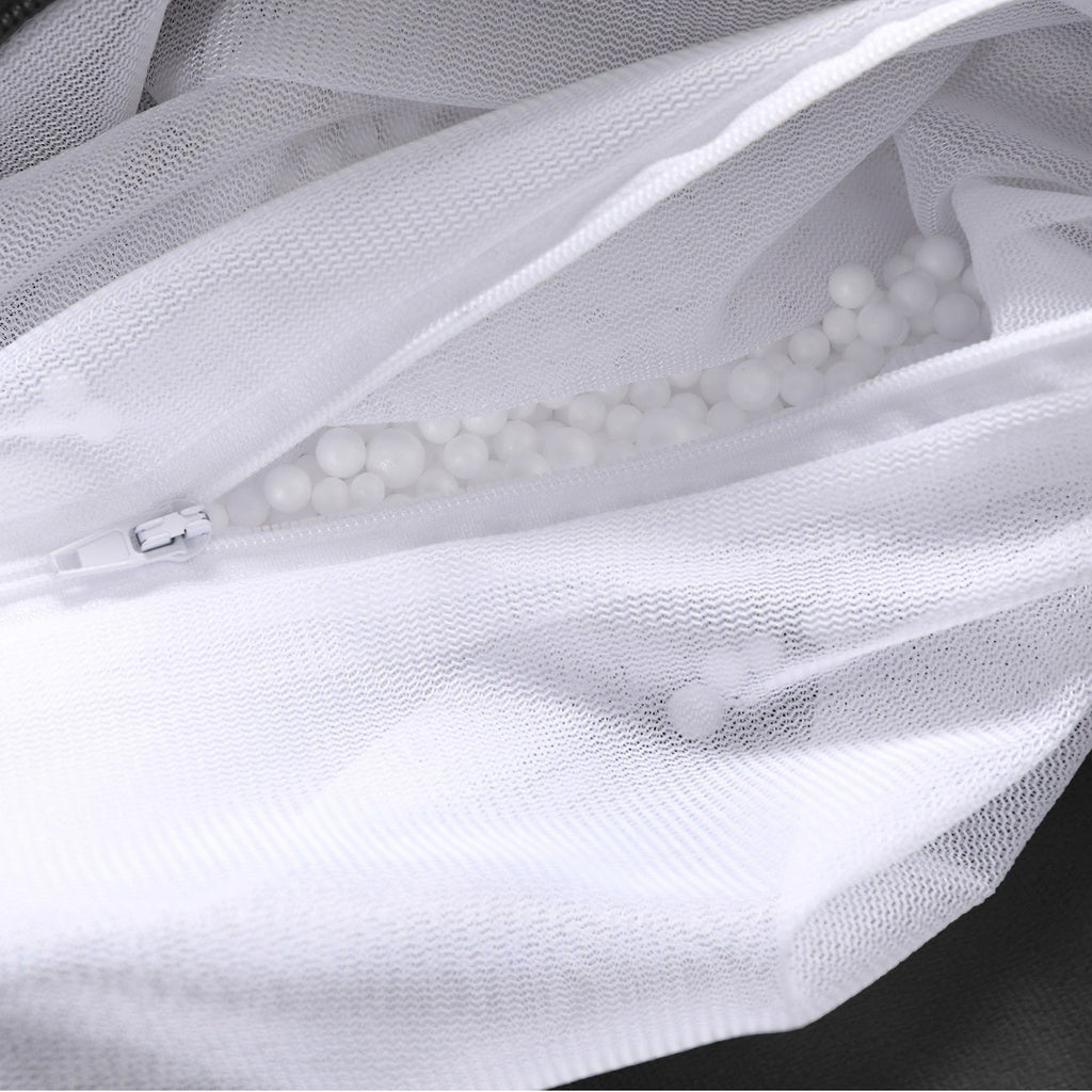 White mesh bag with a zipper containing white pearls on a dark background