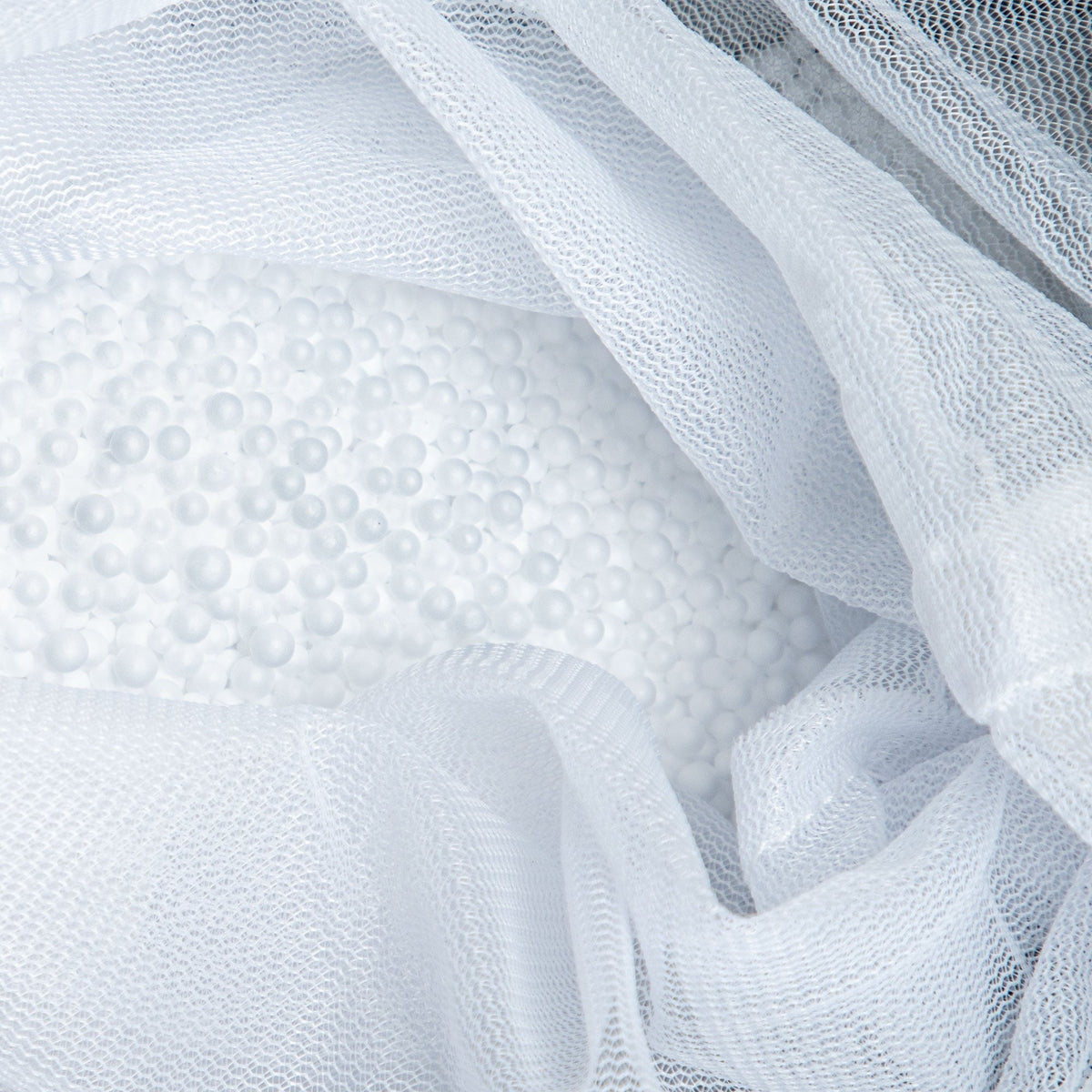 Close-up of textured white fabric with a mesh overlay