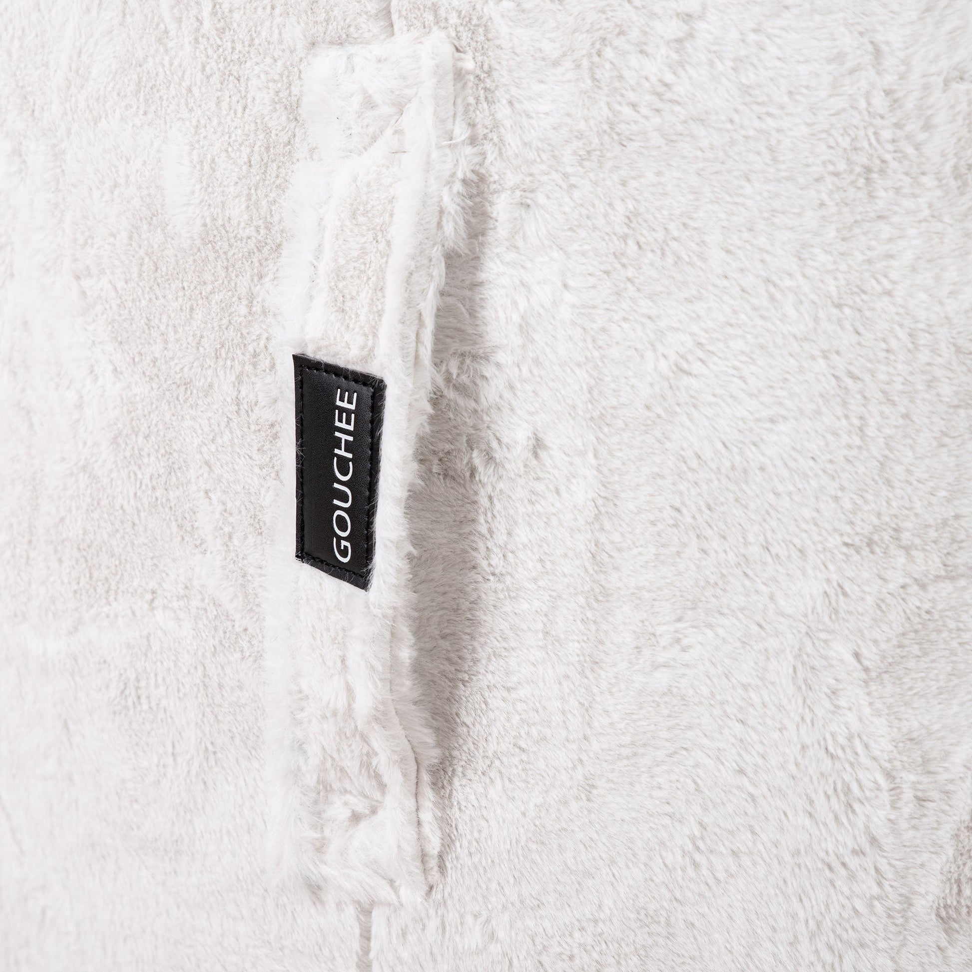 Close-up of a textured white fabric with a 'Gouchée' label.