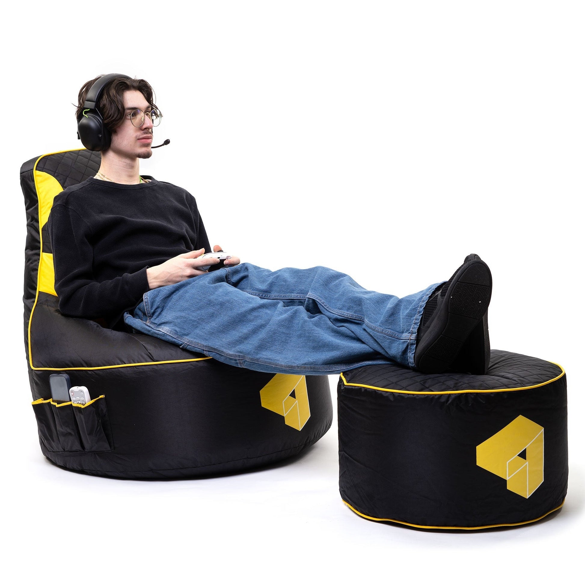 Person sitting on a black and yellow gaming chair with a white background