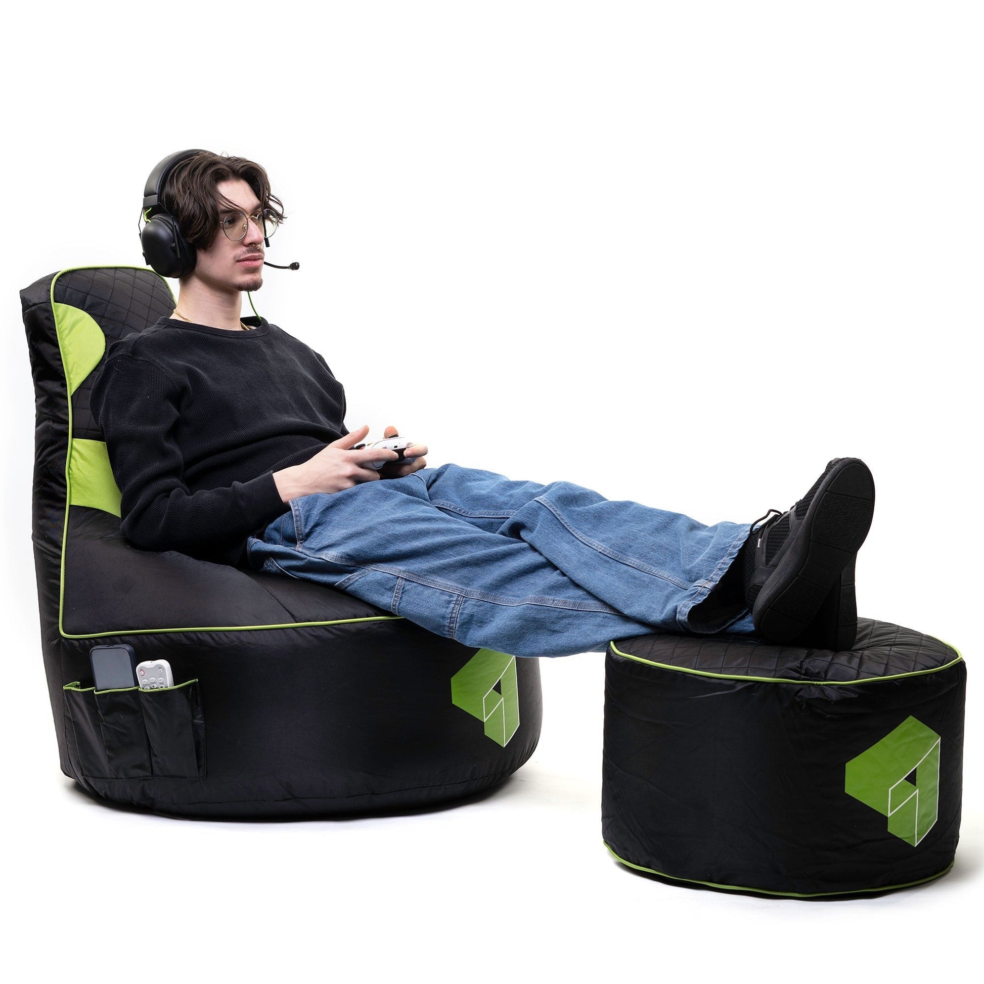 Person sitting in a black and green gaming chair with a white background