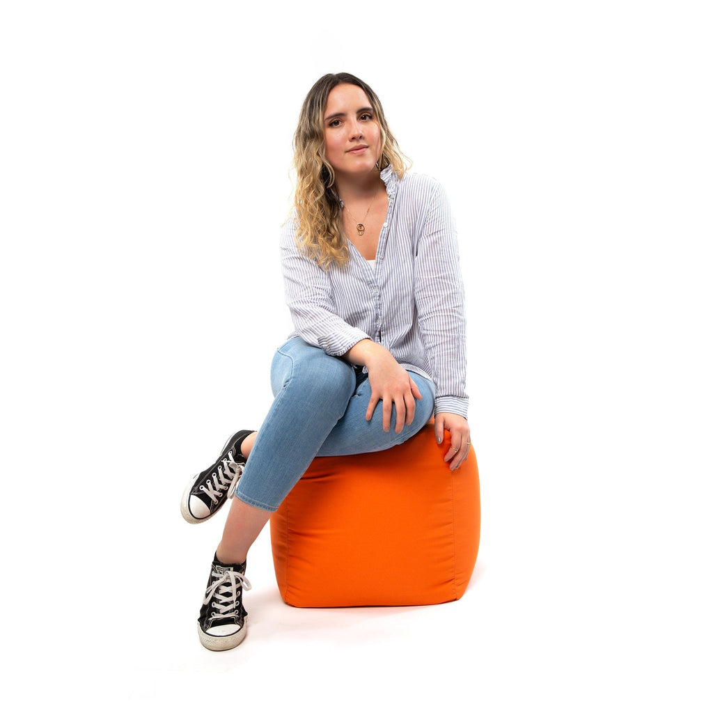 Woman sitting on an orange bean bag chair against a white background