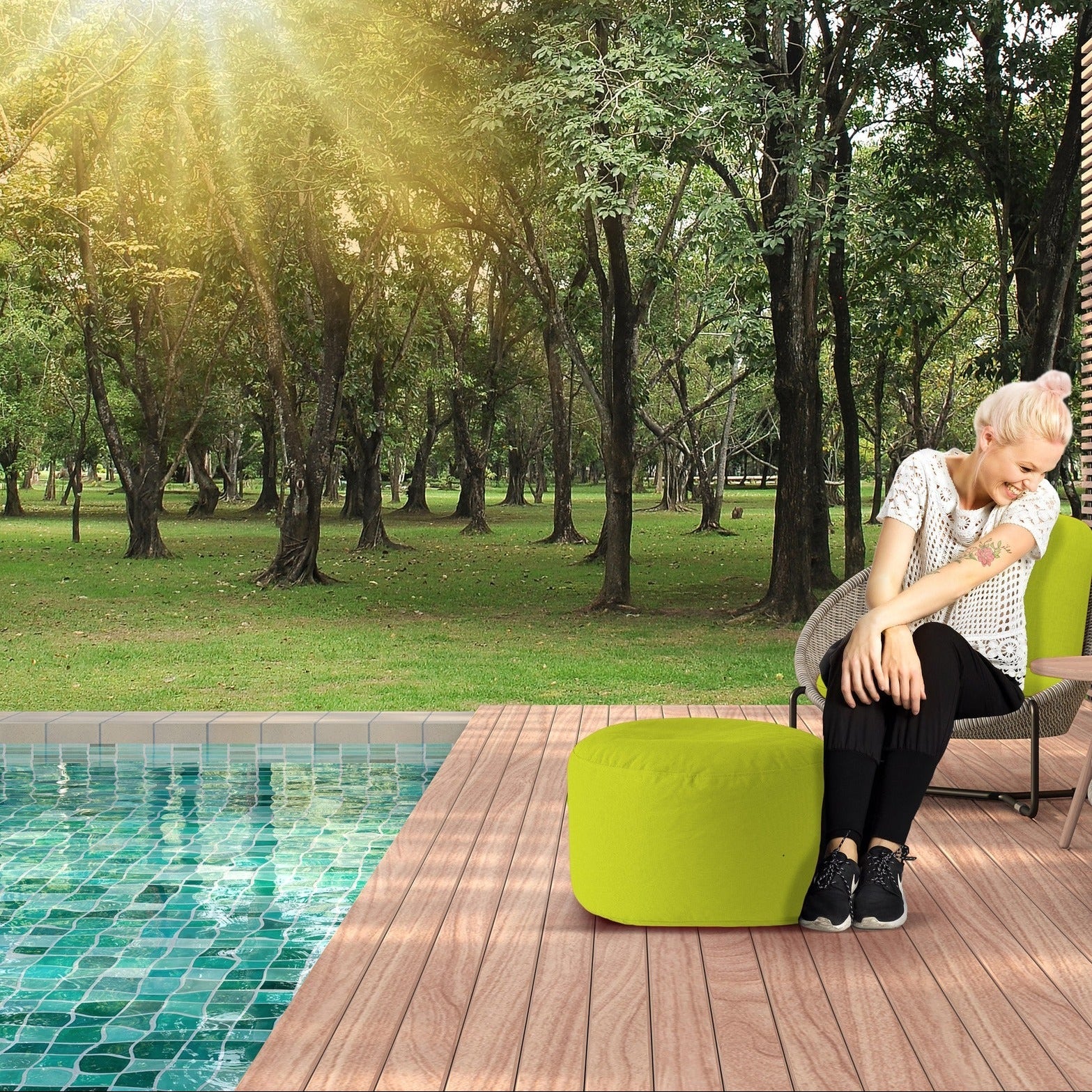 Woman sitting by a pool with greenery in the background