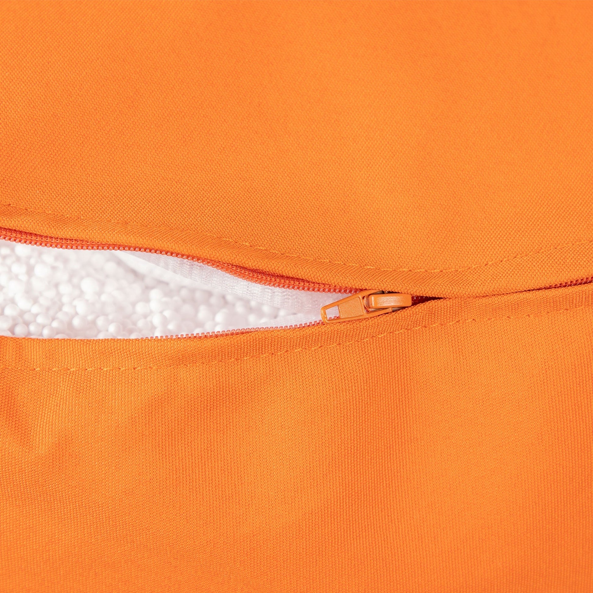 Close-up of an orange bag with a zipper and white interior lining.
