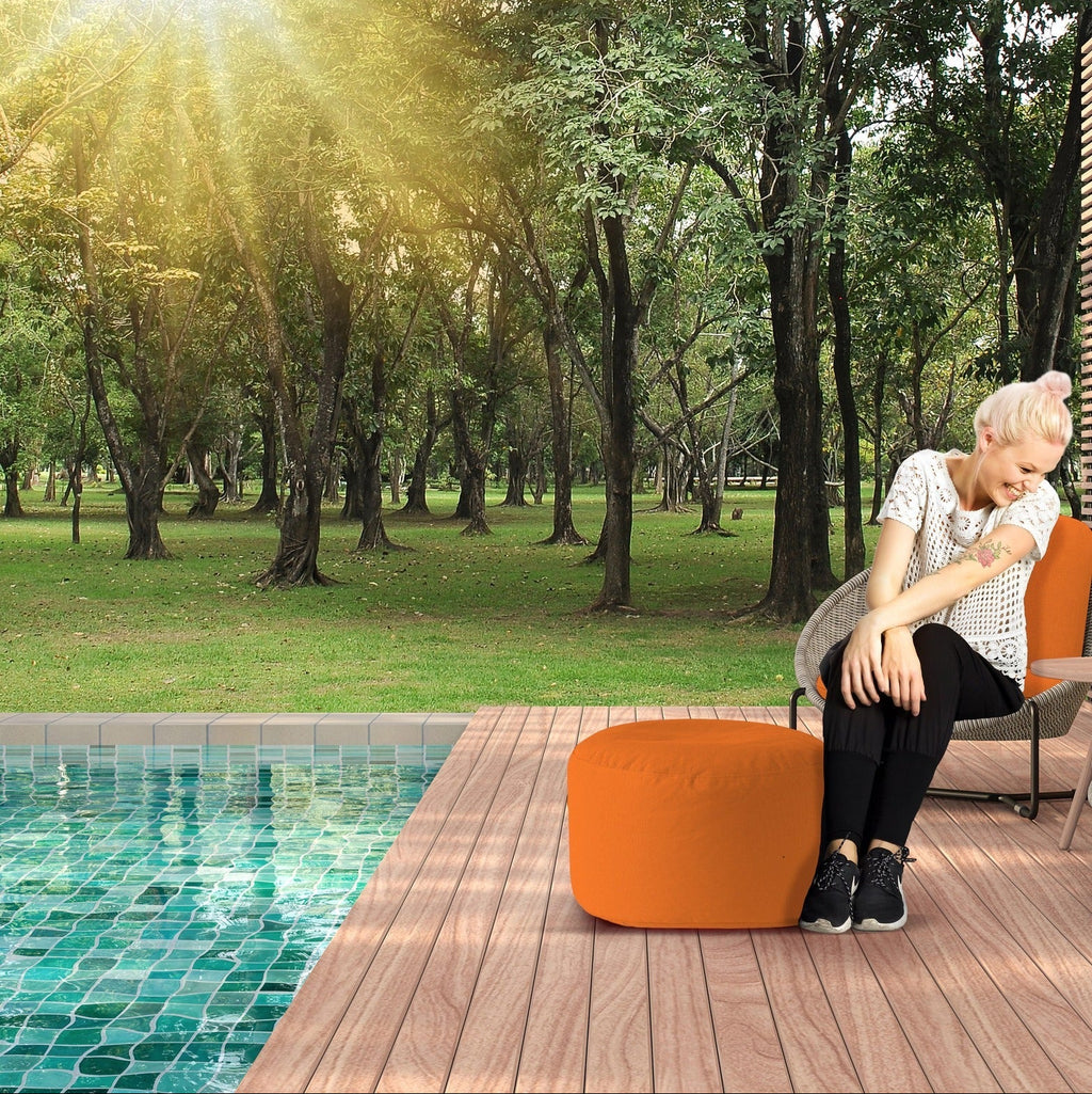 Woman sitting by a pool with trees in the background