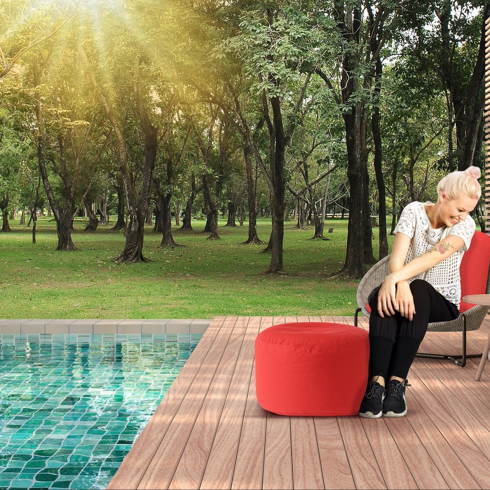 Person sitting by a pool with trees in the background