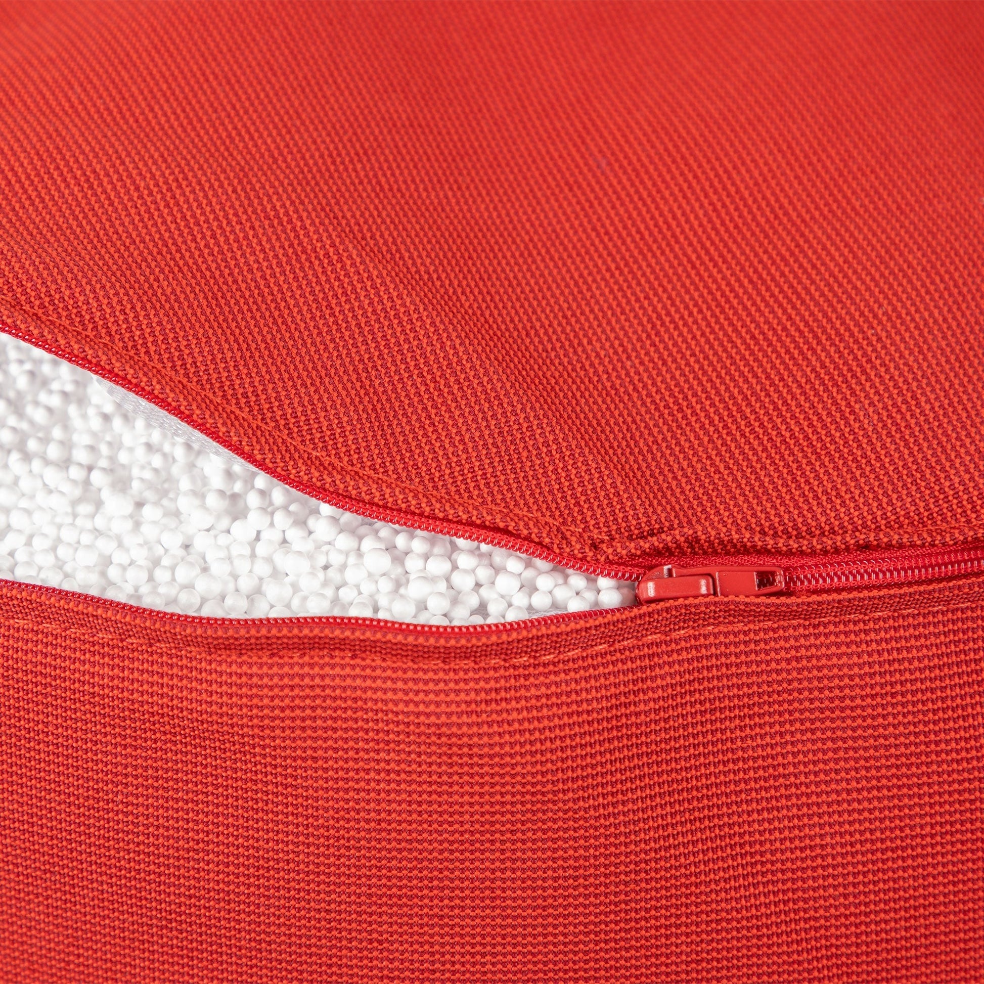 Close-up of a red fabric with a zipper, showing texture and color.
