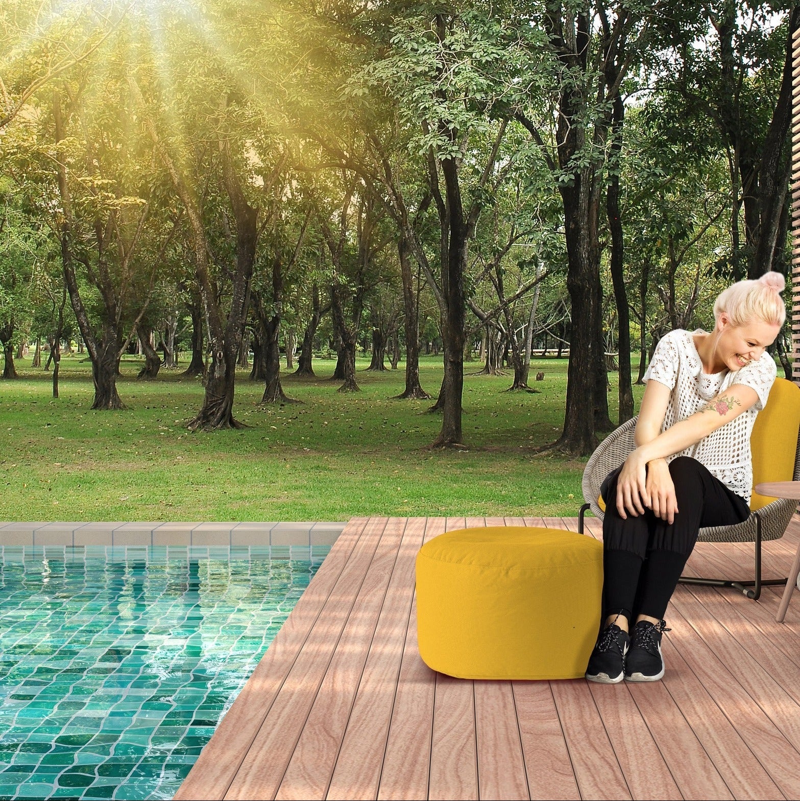 Woman sitting by a pool with trees in the background