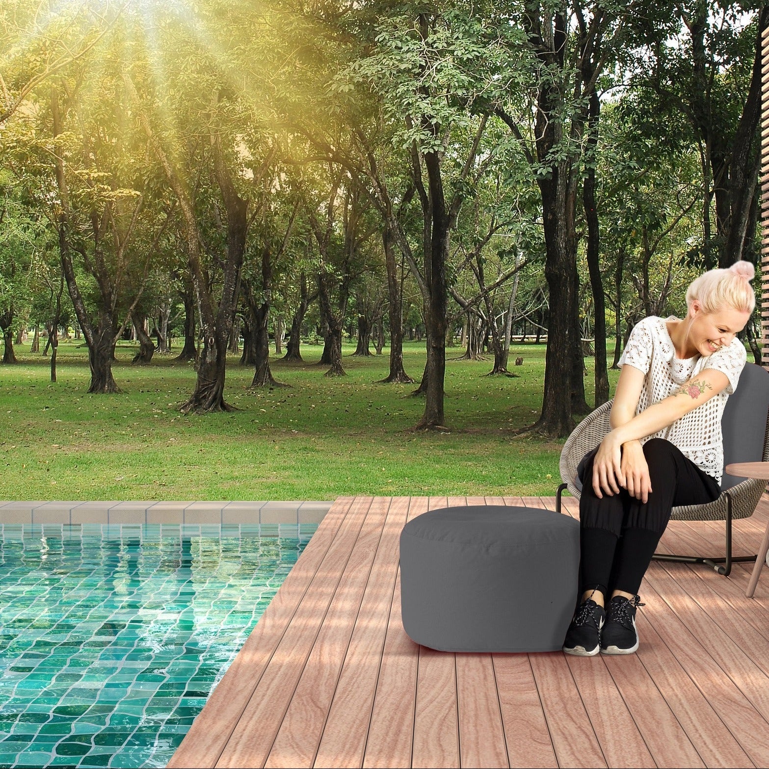 Person sitting by a pool with trees in the background