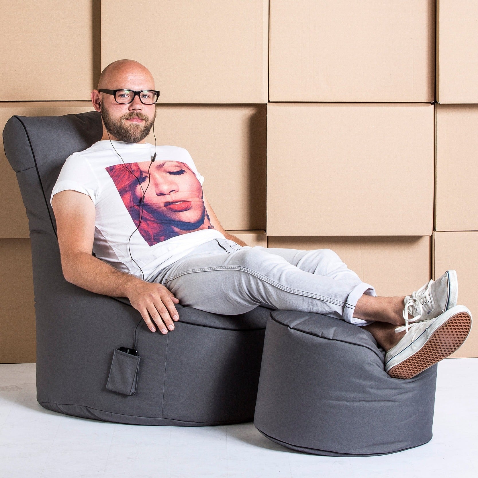 Man sitting on a bean bag chair with a beige wall in the background