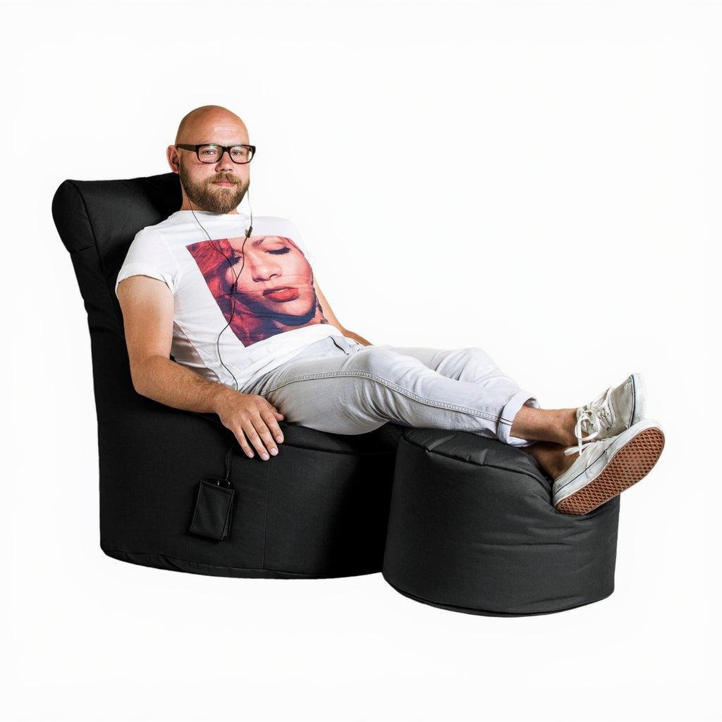 Man sitting on a black bean bag chair with a white background