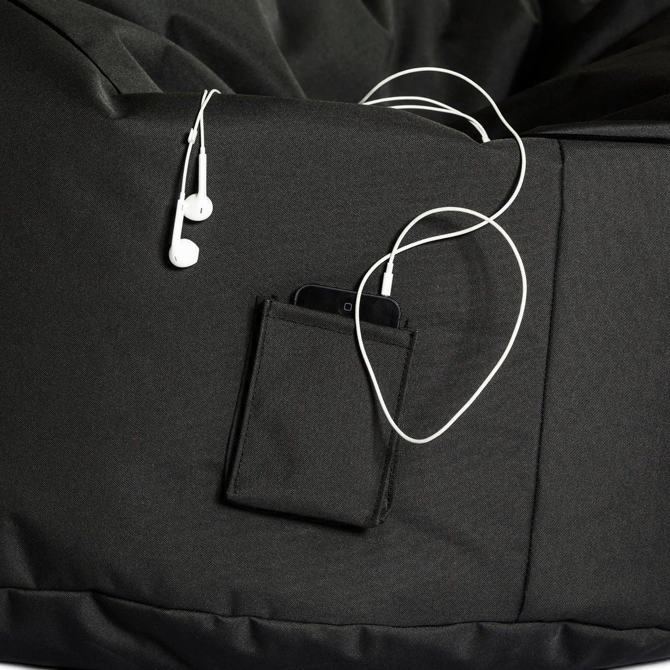 Black bean bag chair with a pocket and earphones on a white background