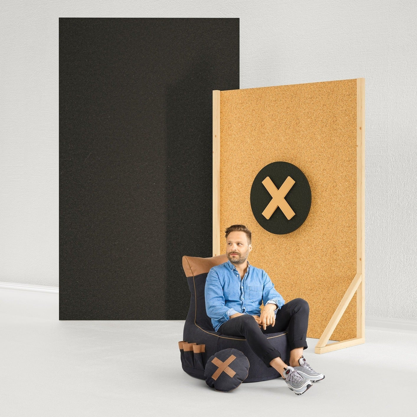 Man sitting in a chair with a design on it, surrounded by black and wooden panels.