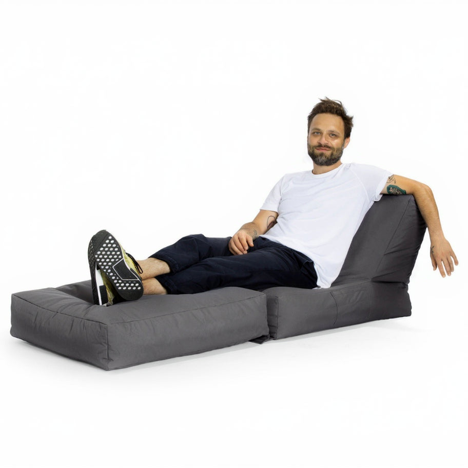 Man sitting on a gray懒人沙发 (lounger) against a white background