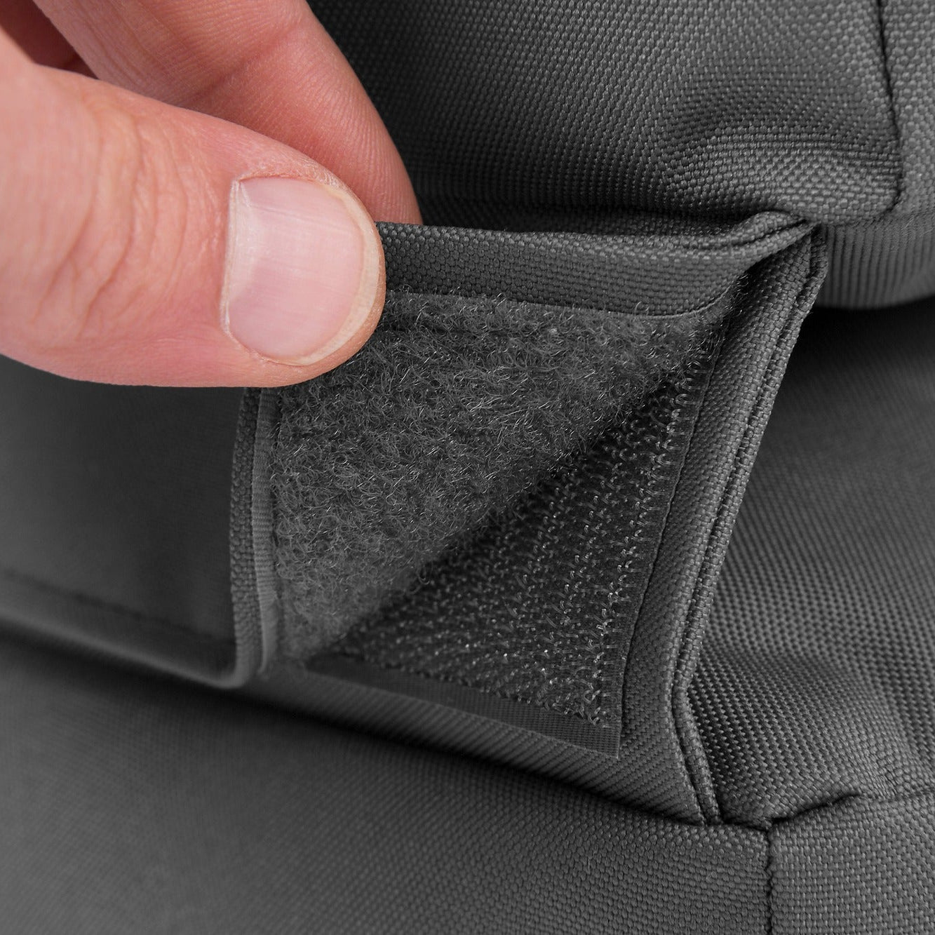 Close-up of a gray fabric with a hand pressing on it