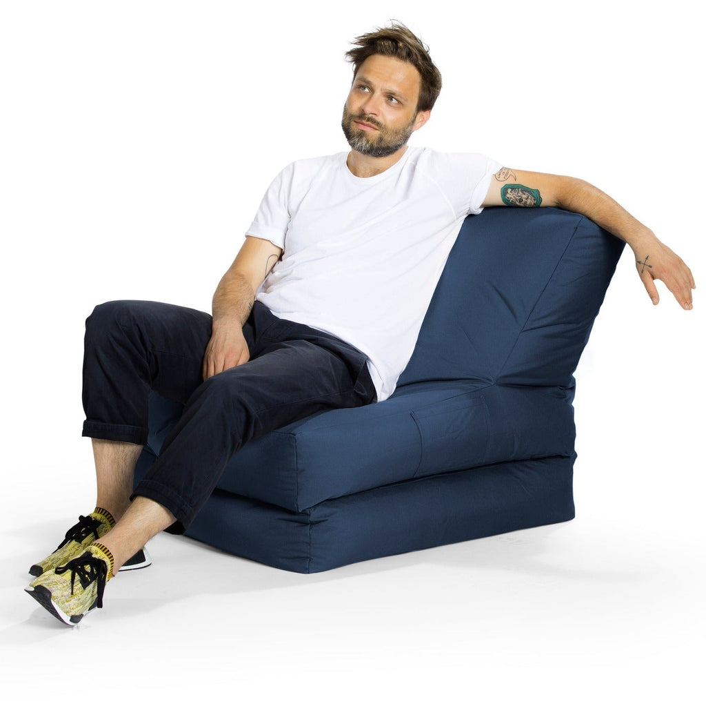 Man sitting on a blue bean bag chair against a white background