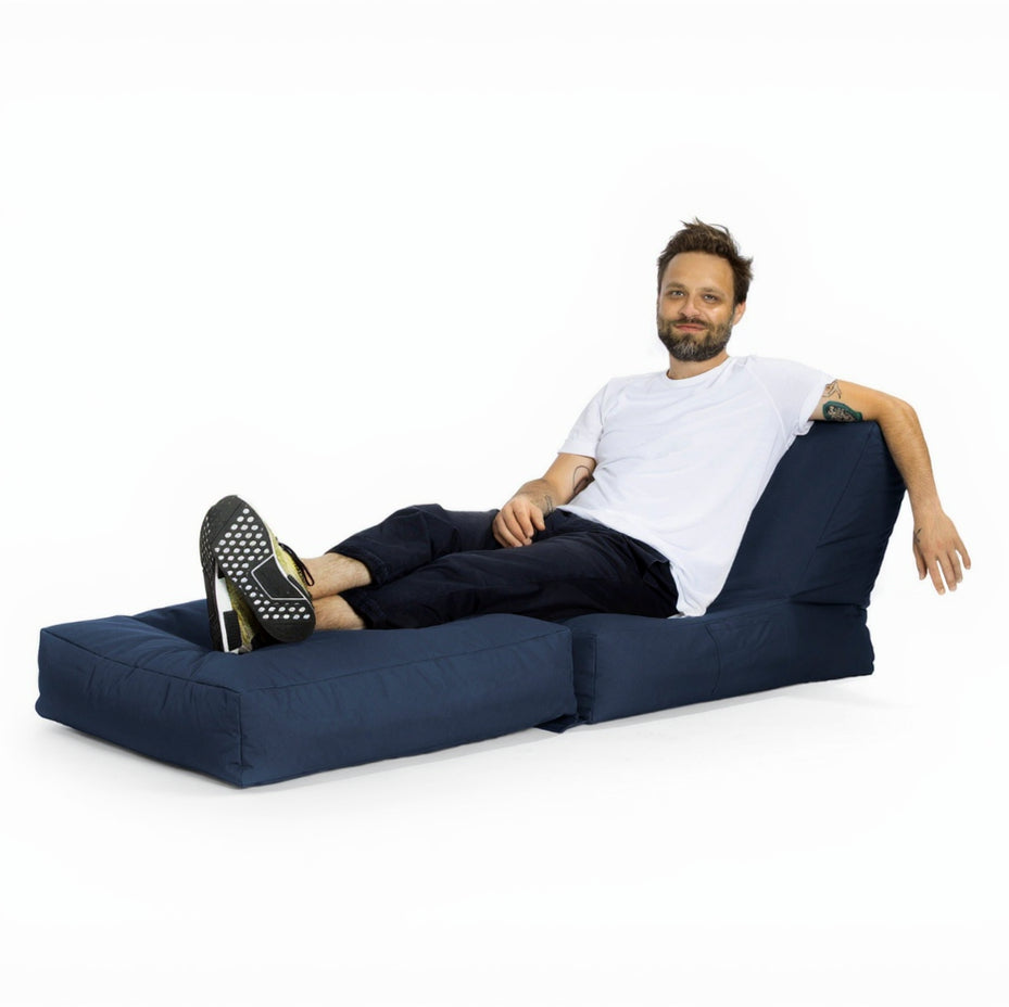 Man sitting on a blue modular sofa against a white background